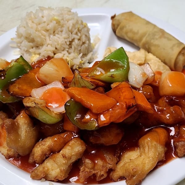 Sweet and sour chicken with bell peppers, onions, pineapple, fried rice, and an egg roll.